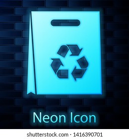 Glowing neon Paper shopping bag with recycle icon isolated on brick wall background. Bag with recycling symbol. Vector Illustration