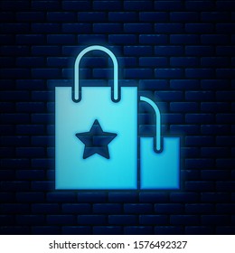 Glowing neon Paper shopping bag icon isolated on brick wall background. Package sign.  Vector Illustration