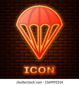 Glowing neon Parachute icon isolated on brick wall background.  Vector Illustration