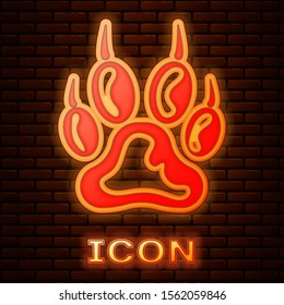 Glowing neon Paw print icon isolated on brick wall background. Dog or cat paw print. Animal track.  Vector Illustration