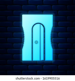 Glowing neon Pencil sharpener icon isolated on brick wall background.  Vector Illustration
