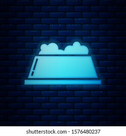 Glowing neon Pet food bowl for cat or dog icon isolated on brick wall background. Dog or cat paw print.  Vector Illustration