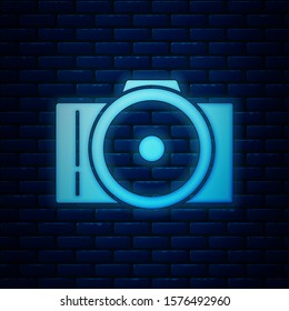 Glowing neon Photo camera icon isolated on brick wall background. Foto camera icon.  Vector Illustration