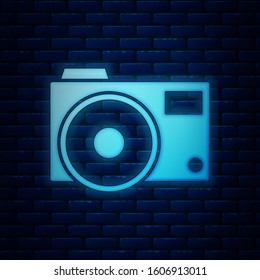Glowing neon Photo camera icon isolated on brick wall background. Foto camera icon.  Vector Illustration