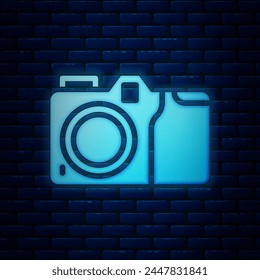 Glowing neon Photo camera icon isolated on brick wall background. Foto camera icon.  Vector