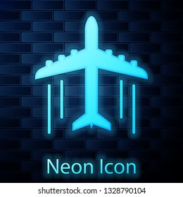 Glowing neon Plane icon isolated on brick wall background. Flying airplane icon. Airliner sign. Vector Illustration