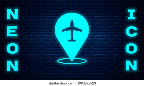 Glowing neon Plane icon isolated on brick wall background. Flying airplane icon. Airliner sign.  Vector