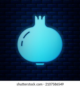 Glowing neon Pomegranate icon isolated on brick wall background. Garnet fruit.  Vector