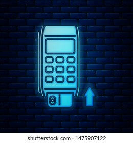 Glowing neon Pos terminal with inserted credit card icon isolated on brick wall background. Payment terminal transaction. Pay by card.  Vector Illustration