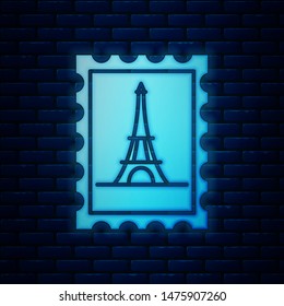 Glowing neon Postal stamp and Eiffel tower icon isolated on brick wall background.  Vector Illustration