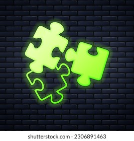 Glowing neon Puzzle pieces toy icon isolated on brick wall background.  Vector
