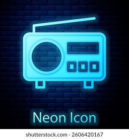 Glowing neon Radio with antenna icon isolated on brick wall background.  Vector