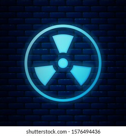 Glowing neon Radioactive icon isolated on brick wall background. Radioactive toxic symbol. Radiation Hazard sign.  Vector Illustration