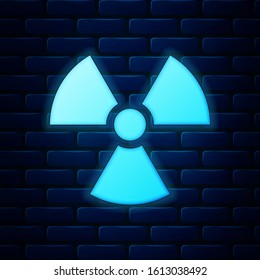 Glowing neon Radioactive icon isolated on brick wall background. Radioactive toxic symbol. Radiation Hazard sign.  Vector Illustration