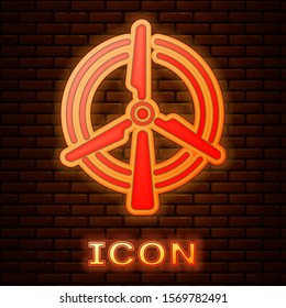 Glowing neon Rotating wind turbine icon isolated on brick wall background. Wind generator sign. Windmill for electric power production.  Vector Illustration