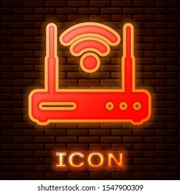 Glowing neon Router and wi-fi signal symbol icon isolated on brick wall background. Wireless ethernet modem router. Computer technology internet.  Vector Illustration