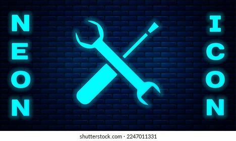 Glowing neon Screwdriver and wrench spanner tools icon isolated on brick wall background. Service tool symbol.  Vector Illustration