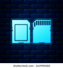Glowing neon SD card icon isolated on brick wall background. Memory card. Adapter icon.  Vector Illustration
