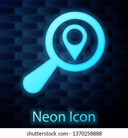 Glowing neon Search location icon isolated on brick wall background. Magnifying glass with pointer sign. Vector Illustration