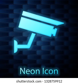 Glowing neon Security camera icon isolated on brick wall background. Vector Illustration