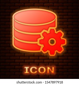 Glowing neon Setting database server icon isolated on brick wall background. Database Center.  Vector Illustration