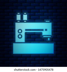 Glowing neon Sewing machine icon isolated on brick wall background.  Vector Illustration