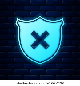 Glowing neon Shield and cross x mark icon isolated on brick wall background. Denied disapproved sign. Protection, safety, security concept.  Vector Illustration