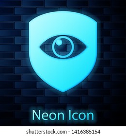 Glowing neon Shield and eye icon isolated on brick wall background. Security, safety, protection, privacy concept. Vector Illustration