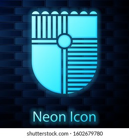 Glowing neon Shield for game icon isolated on brick wall background.  Vector Illustration