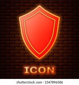 Glowing neon Shield icon isolated on brick wall background. Guard sign.  Vector Illustration