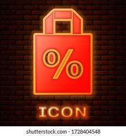 Glowing neon Shoping bag with an inscription percent discount icon isolated on brick wall background. Handbag sign. Vector Illustration