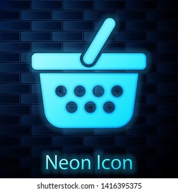 Glowing neon Shopping basket icon isolated on brick wall background. Online buying concept. Delivery service sign. Shopping cart symbol. Vector Illustration