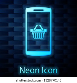Glowing neon Shopping basket on screen smartphone icon isolated on brick wall background. Concept e-commerce, e-business, online business marketing. Vector Illustration