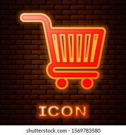 Glowing neon Shopping cart icon isolated on brick wall background. Online buying concept. Delivery service sign. Supermarket basket symbol.  Vector Illustration