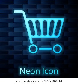 Glowing neon Shopping cart icon isolated on brick wall background. Online buying concept. Delivery service sign. Supermarket basket symbol. Vector Illustration