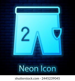Glowing neon Shorts for playing football icon isolated on brick wall background.  Vector