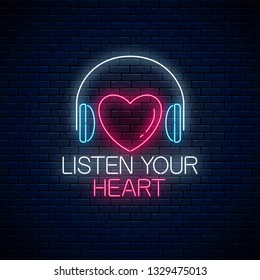 Glowing neon sign with headphones, heart shape and listen your heart slogan on dark brick wall background. Call to listen symbol with cheering inscription. Vector illustration.
