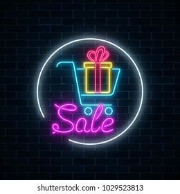 Glowing neon sign of supermarket shopping cart with gift box on a dark brick wall background. Luminous advertising sale banner. Neon light effects store basket. Vector illustration.