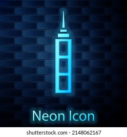 Glowing neon Skyscraper icon isolated on brick wall background. Metropolis architecture panoramic landscape. Vector