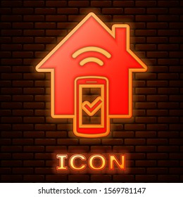 Glowing neon Smart home - remote control system icon isolated on brick wall background.  Vector Illustration