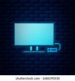 Glowing neon Smart Tv icon isolated on brick wall background. Television sign.  Vector Illustration