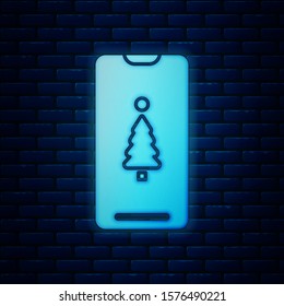 Glowing neon Smartphone with gift box on the screen icon isolated on brick wall background. Merry Christmas and Happy New Year.  Vector Illustration