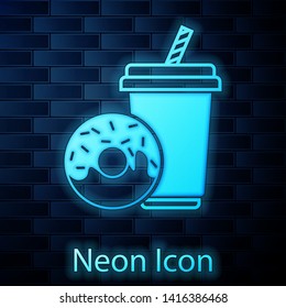 Glowing neon Soda drink with drinking straw and donut icon isolated on brick wall background. Fast food symbol. Vector Illustration