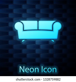 Glowing neon Sofa icon isolated on brick wall background. Vector Illustration
