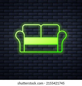 Leuchtendes Neon-Sofa-Symbol einzeln auf Backsteinwandhintergrund.  Vektorgrafik