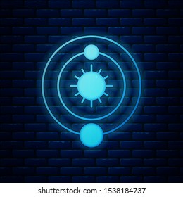Glowing neon Solar system icon isolated on brick wall background. The planets revolve around the star.  Vector Illustration