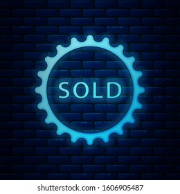 Glowing neon Sold label icon isolated on brick wall background.  Vector Illustration