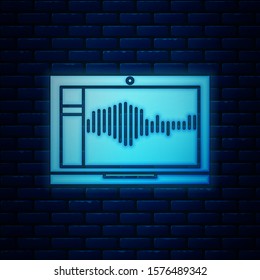 Glowing neon Sound or audio recorder or editor software on laptop icon isolated on brick wall background.  Vector Illustration