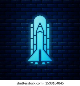 Glowing neon Space shuttle and rockets icon isolated on brick wall background.  Vector Illustration