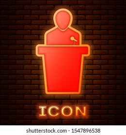 Glowing neon Speaker icon isolated on brick wall background. Orator speaking from tribune. Public speech. Person on podium.  Vector Illustration